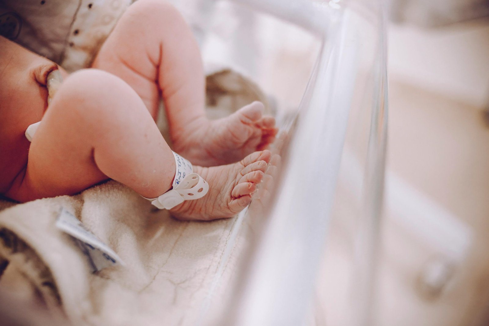 Close-up of newborn baby feet with hospital ID bracelet, symbolizing new beginnings.